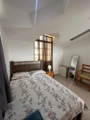 a bedroom with a bed with a floral bedspread on it at Casa Mendes- Quarto individual in Praia