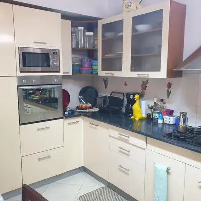 a kitchen with white cabinets and a black counter top at Gamboa-1 Praia in Praia