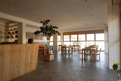 a dining room with tables and chairs and windows at Aquiles Eco Hotel in São Pedro