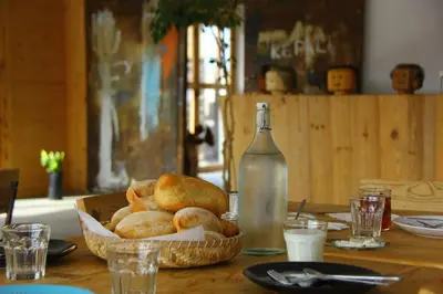 a basket of bread on a table with a bottle of milk at Aquiles Eco Hotel in São Pedro