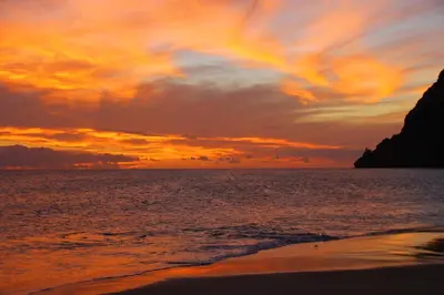 a sunset on the beach with a rainbow in the sky at Aquiles Eco Hotel in São Pedro