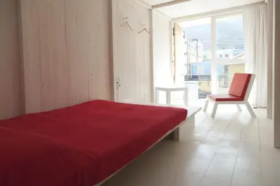 a bedroom with a bed and a chair and a window at Aquiles Eco Hotel in São Pedro