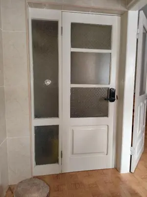 a white door with glass panels in a room at Huizenmarkt Caboverde in Mindelo