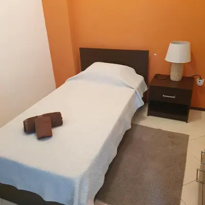 a bedroom with a white bed and a night stand with a lamp at Gamboa-2 Praia in Praia