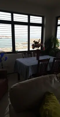 a living room with a table and chairs and windows at Gamboa-2 Praia in Praia