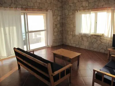 a room with a bench and a table and windows at Villa 4 Stella Maris - Ilha do Maio in Vila do Maio