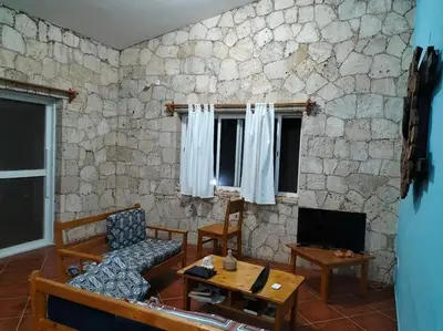 a living room with a stone wall at Villa 4 Stella Maris - Ilha do Maio in Vila do Maio