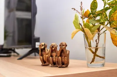 three small wooden figurines on a desk next to a vase at Casa Irma in Santa Maria