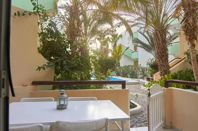 a table and chairs in a courtyard with palm trees at Casa Irma in Santa Maria