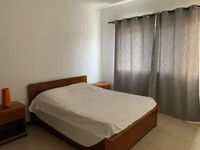 a small bedroom with a bed and a window at Vannimar t2 in Porto Novo