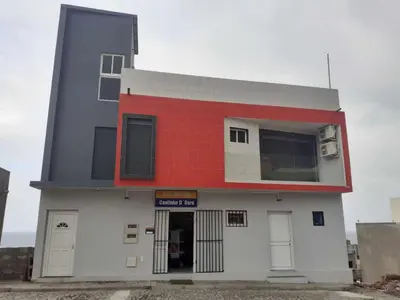 a building with a red and white at Casa Cantinho d`ouro in Ponta do Sol