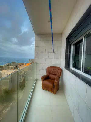 a brown leather chair sitting on a balcony at Casa Cantinho d`ouro in Ponta do Sol