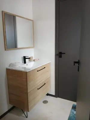 a bathroom with a sink and a mirror and a door at Casa Cantinho d`ouro in Ponta do Sol