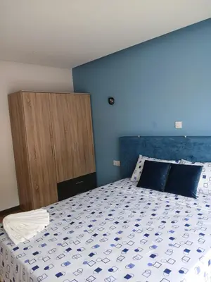 a bedroom with a large bed and a wooden cabinet at Casa Cantinho d`ouro in Ponta do Sol