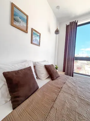 a bedroom with a bed with a large window at Boa Mindelo City in Mindelo