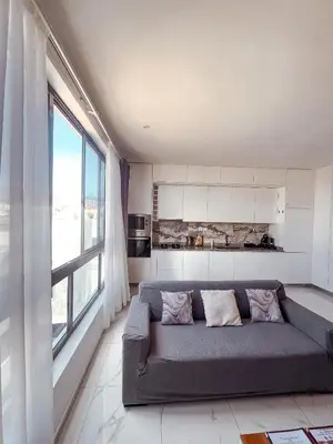 a living room with a couch and a large window at Boa Mindelo City in Mindelo