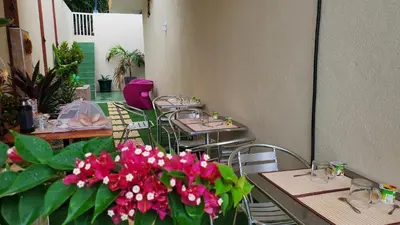 a restaurant with tables and chairs with pink flowers at Fajã Beach House in Fajã