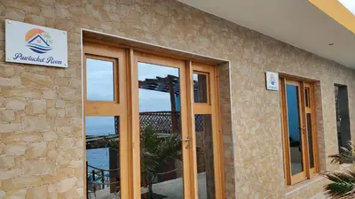 a building with sliding glass doors with a view of the ocean at Fajã Beach House in Fajã