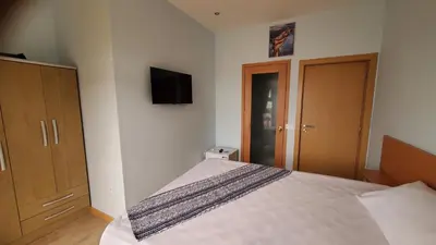 a bedroom with a bed and a tv on the wall at Fajã Beach House in Fajã