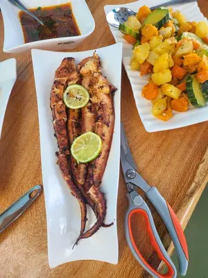 two plates of food with fish and vegetables on a table at Fajã Beach House in Fajã