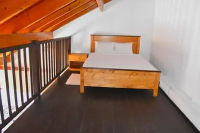 a bedroom with a bed with a wooden bed frame at Santa Maria Homely Flat in Santa Maria