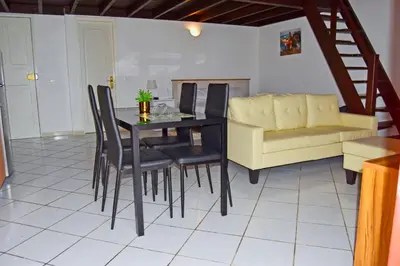 a dining room with a table and chairs and a couch at Santa Maria Homely Flat in Santa Maria