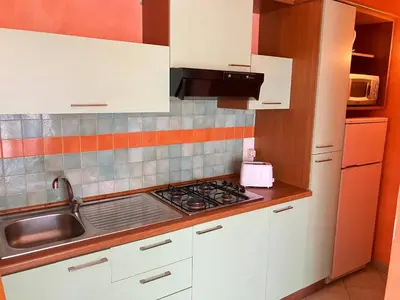 a kitchen with white cabinets and a stove top oven at Time Out DjadSal Residence AC Wifi in Santa Maria