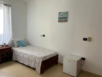 a small bedroom with a bed and a table at City Center Near Beach B&B in Tarrafal