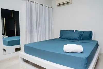 a bedroom with a blue bed and a mirror at Nice And Modern with king size bed in Praia