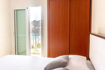 a bedroom with a bed and a large window at Bliss Apartments - T2 Nicole in Mindelo