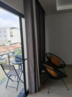 a room with a balcony with two chairs and a table at Charming House Tarrafal in Tarrafal
