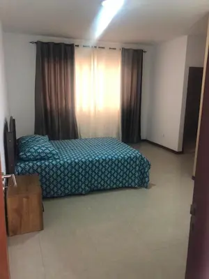 a bedroom with a bed with a blue comforter at Apartamento Oiá Mindelo in Mindelo