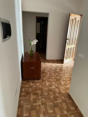 a hallway with a vase of flowers on a dresser at Apartment T3 for rent in Porto Novo in Porto Novo