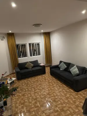 a living room with two black couches and a wooden floor at Apartment T3 for rent in Porto Novo in Porto Novo