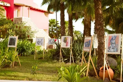 a group of paintings in front of palm trees at Hotel Santantao Art Resort in Porto Novo