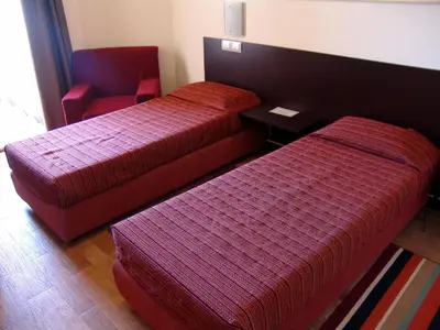 a hotel room with two beds and a chair at Hotel Santantao Art Resort in Porto Novo
