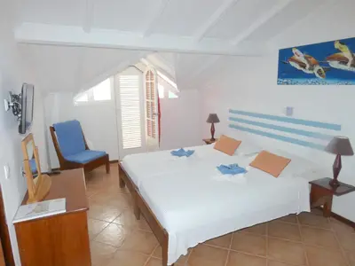 a bedroom with a white bed and a blue chair at Hotel MiraBela in Santa Maria