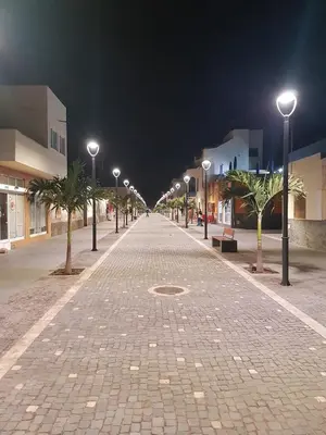 a cobblestone street with street lights at night at Hotel MiraBela in Santa Maria