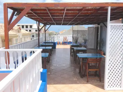 a patio with tables and chairs on a balcony at Hotel MiraBela in Santa Maria