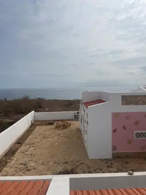 a house on the beach with the ocean in the background at Serra's Village in Vila do Maio