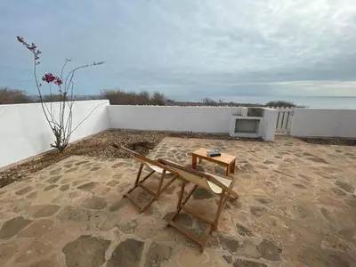 a patio with a table and a chair and a tv at Serra's Village in Vila do Maio