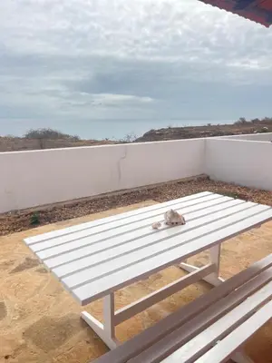 a white bench sitting on top of a white wall at Serra's Village in Vila do Maio