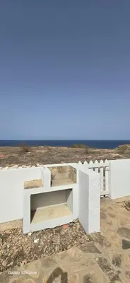 a white bench sitting on top of a building at Serra's Village in Vila do Maio