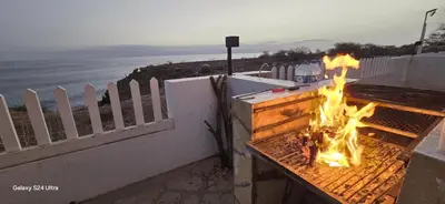a fire in a grill on the side of a wall at Serra's Village in Vila do Maio