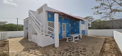 a small house with a staircase on the side of it at Serra's Village in Vila do Maio