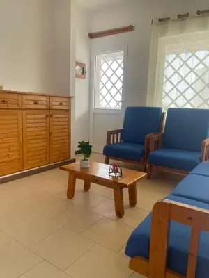 a living room with blue chairs and a coffee table at Serra's Village in Vila do Maio