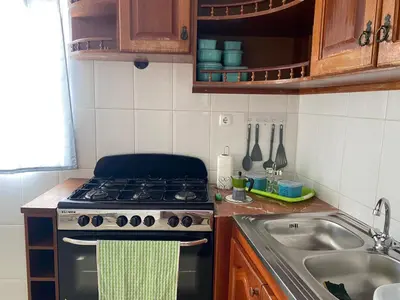 a small kitchen with a stove and a sink at Katila-Rooms-Lima in Espargos