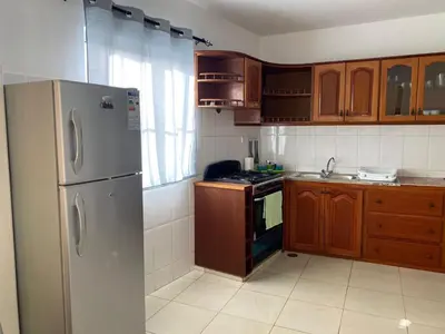 a kitchen with a stainless steel refrigerator and wooden cabinets at Katila-Rooms-Lima in Espargos