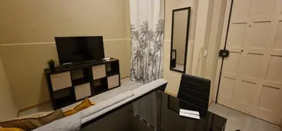 a living room with a tv and a door at City Center Mindelo 37 in Mindelo