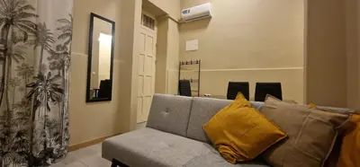 a living room with a gray couch with yellow pillows at City Center Mindelo 37 in Mindelo